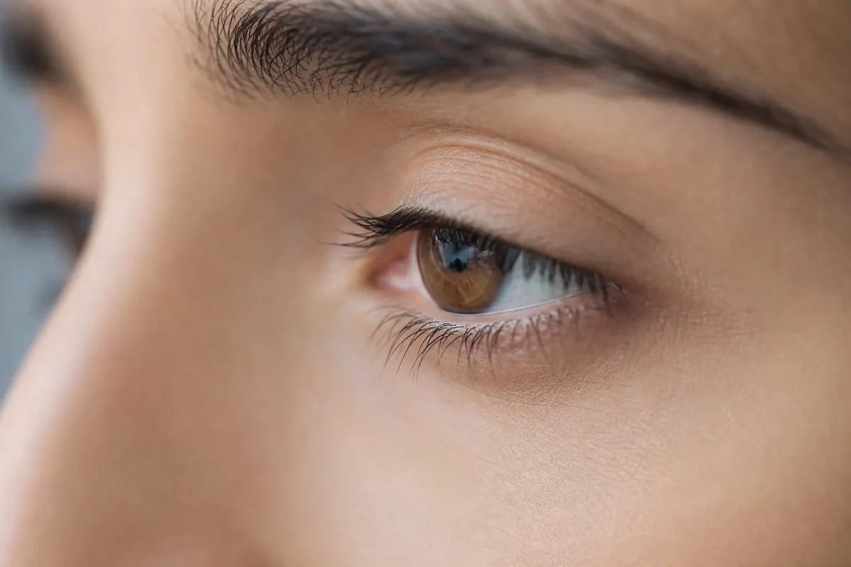 Gros plan calme sur le contour d'un œil, lumière naturelle douce, aucun autre détail du visage visible.