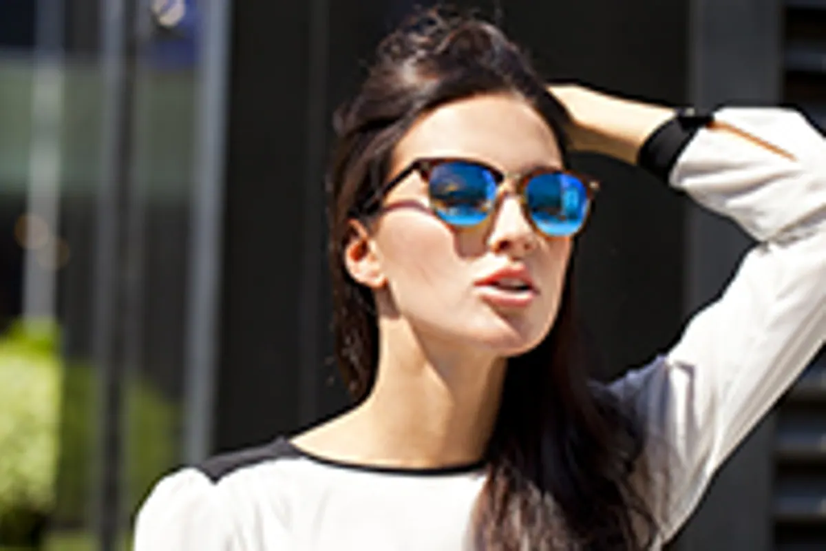 Personne portant des lunettes de soleil à verres teintés et monture couvrante en extérieur lumineux.