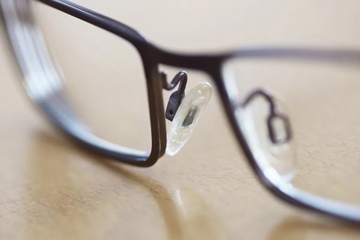 Opticien présentant différentes options de verres correcteurs devant une monture de lunettes