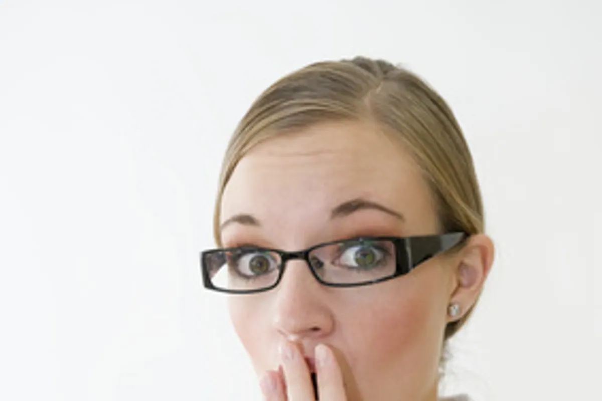 Une paire de lunettes de vue posée devant un ordinateur affichant une page de comparatif d’opticiens en ligne.