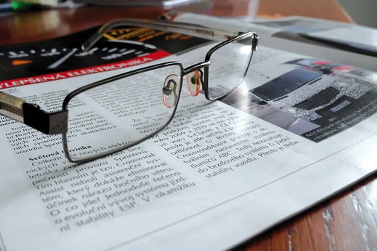 Personne comparant une monture de lunettes et une ordonnance sur un ordinateur portable