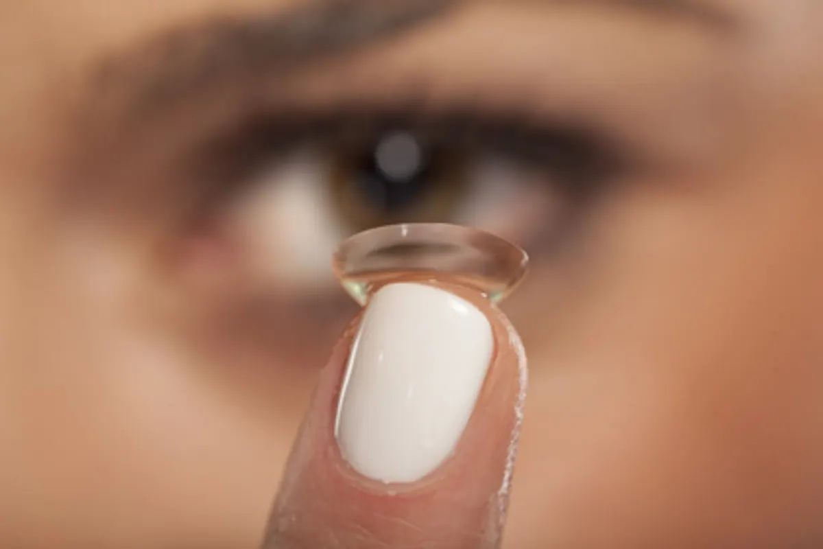 Personne portant des lentilles de contact et des lunettes de soleil à l'extérieur