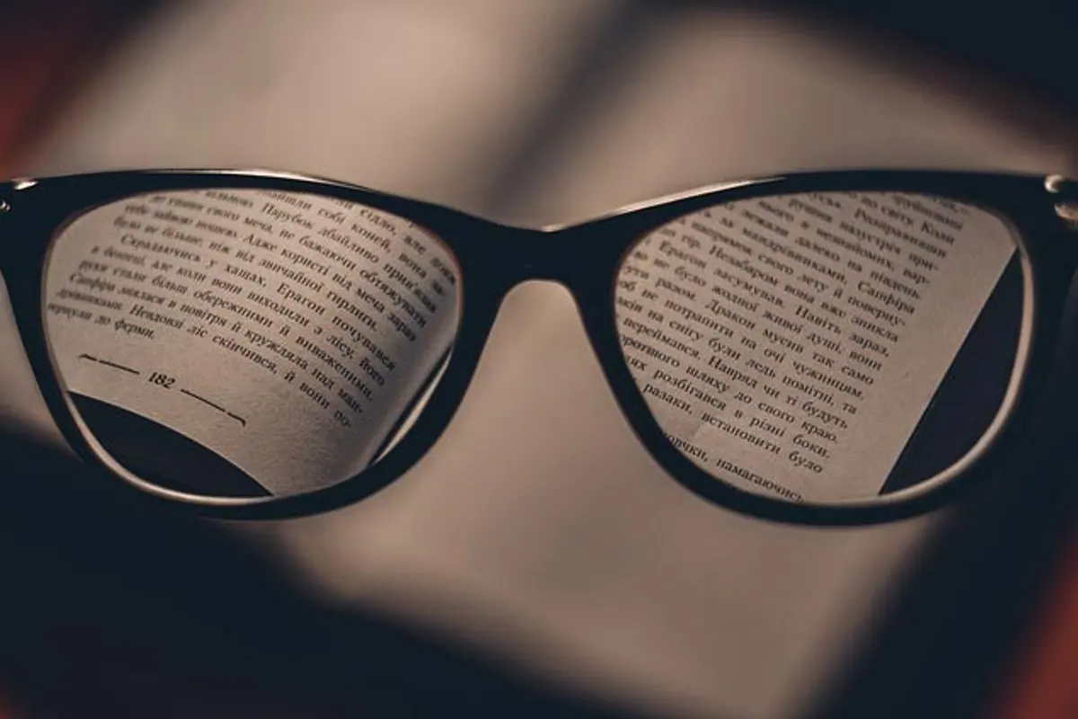 Une paire de lunettes de vue posée à côté d’un étui et de lentilles de contact.
