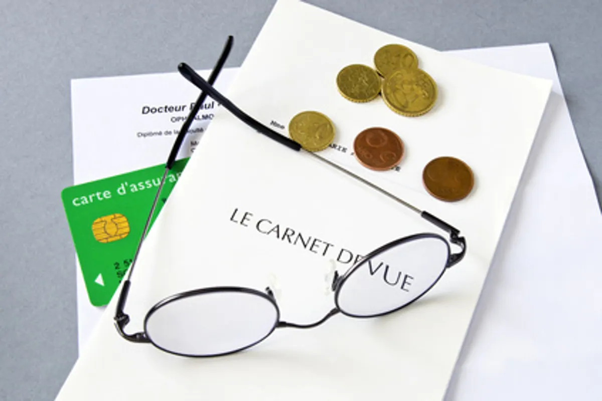 Ordonnance de lunettes, paire de lunettes et devis d’opticien posés sur une table pour comparer une mutuelle optique.