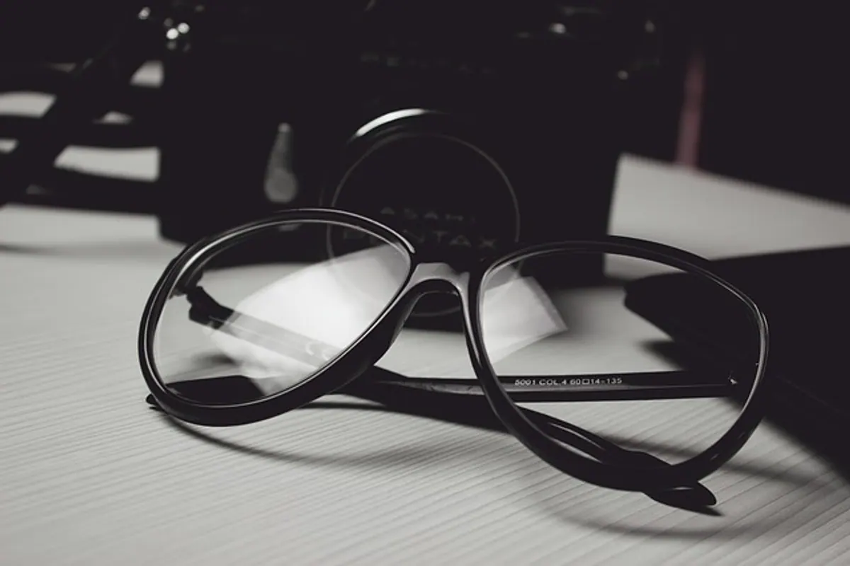 Opticien ajustant une paire de lunettes sur le visage d’une cliente afin de vérifier le centrage des verres.