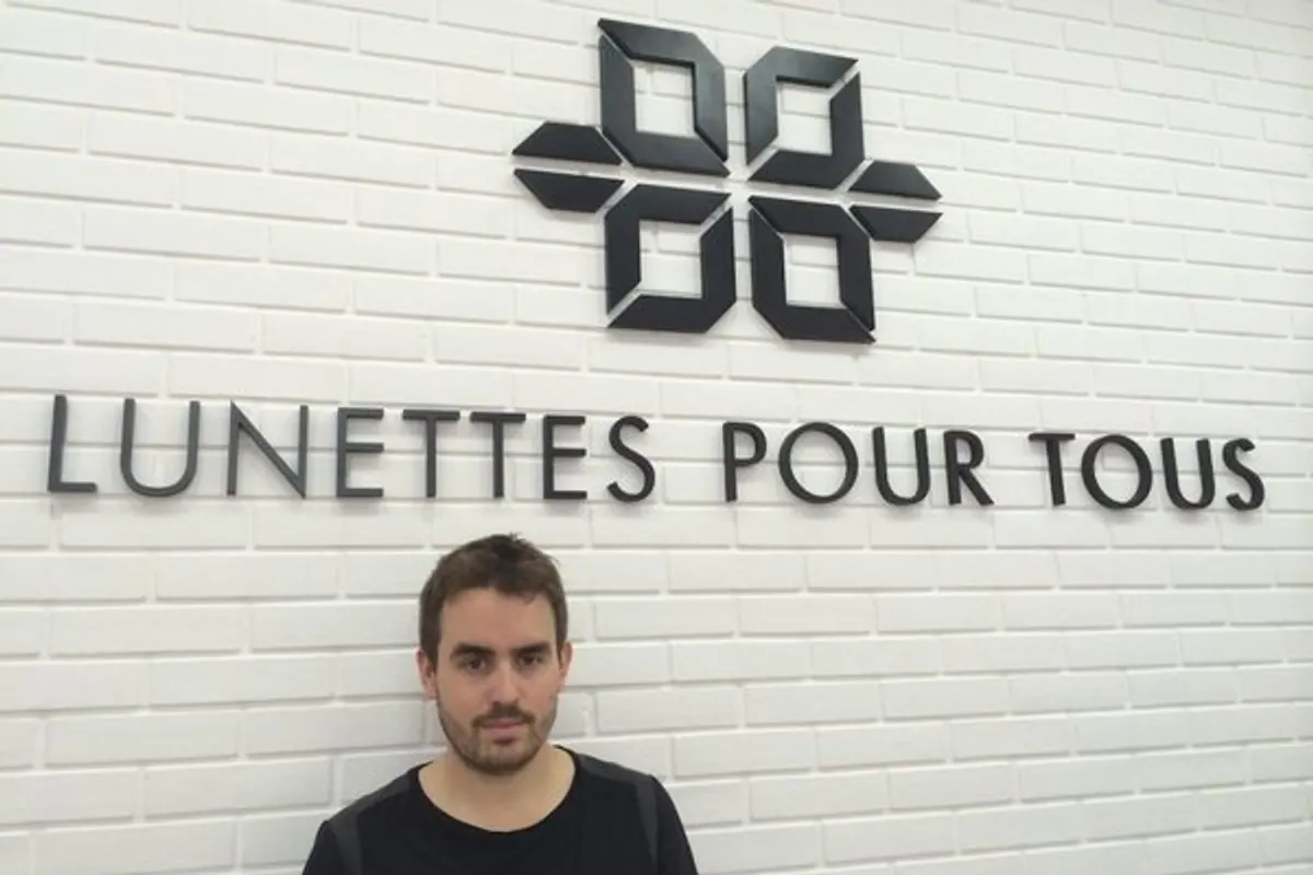 Monture de lunettes de vue posée sur un comptoir d’opticien avec un devis et une ordonnance.