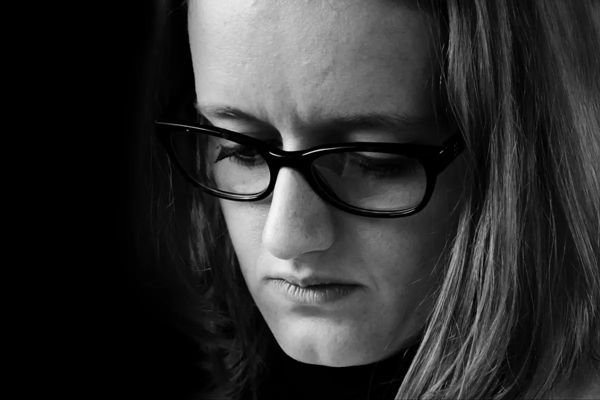 Gros plan d’une personne ajustant les plaquettes de ses lunettes sur le nez.