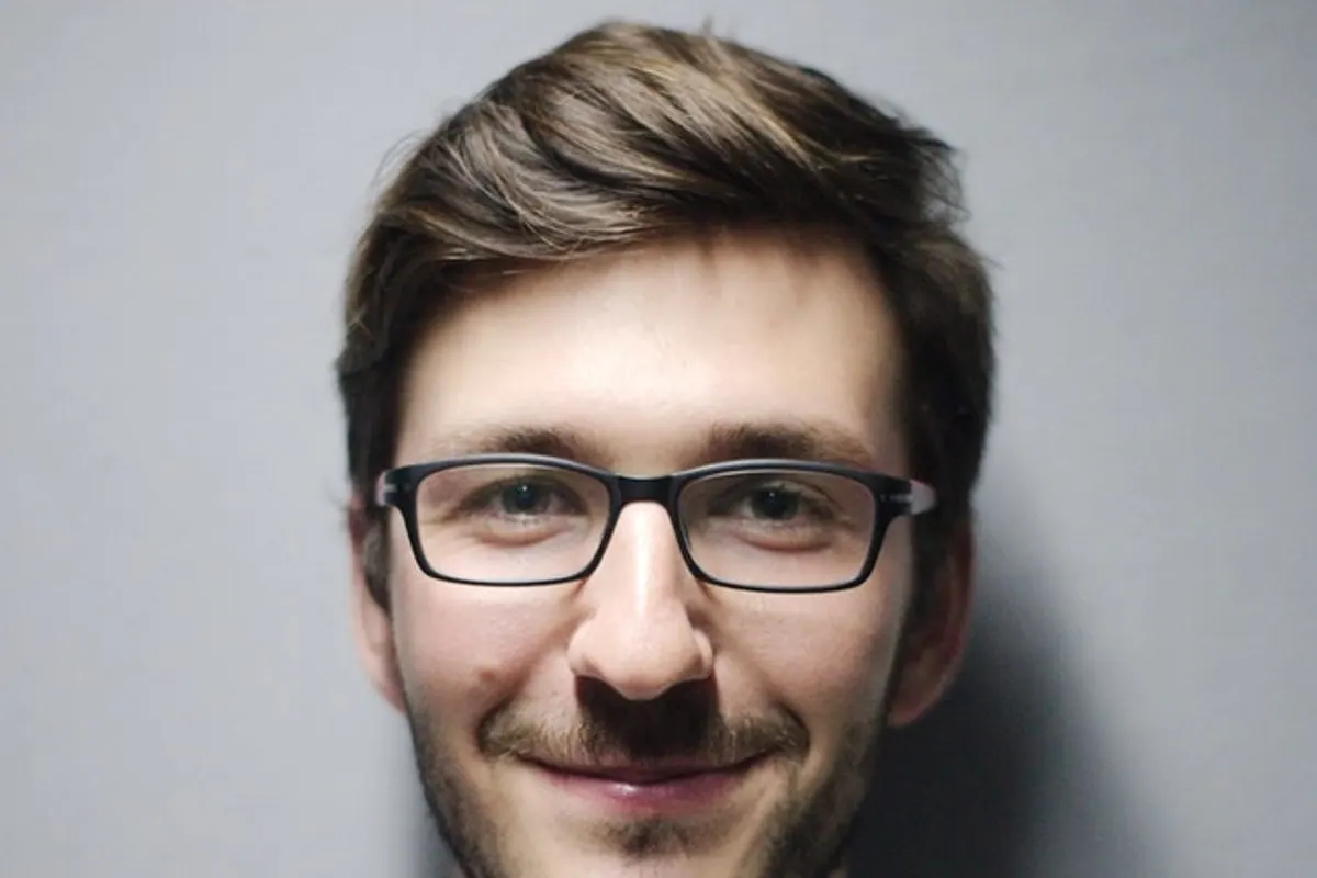 Personne examinant une paire de lunettes de vue avec des verres rayés et une monture légèrement déformée.