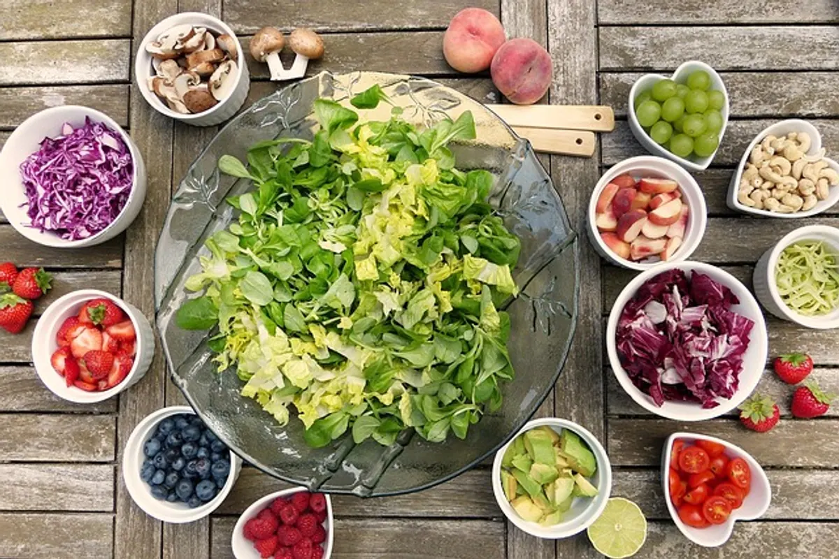 Assiette variée avec légumes, légumineuses, poisson et lunettes de soleil posées à côté