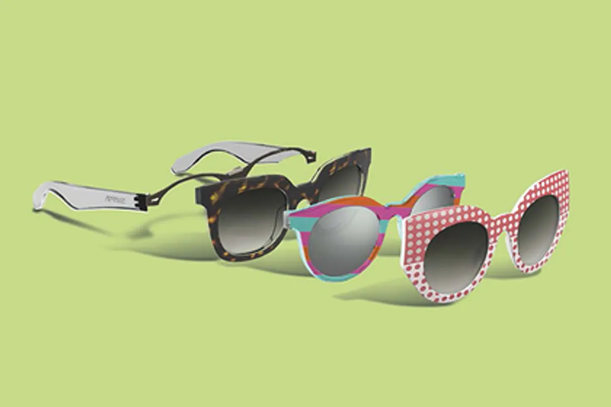 Paire de lunettes de soleil posée sur une surface claire, avec verres teintés et monture sombre.