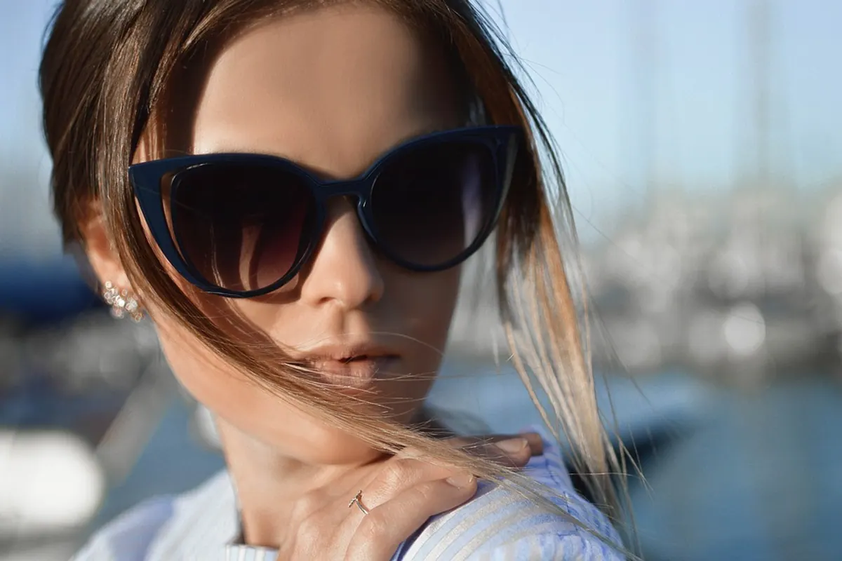 Personne portant des lunettes de soleil enveloppantes lors d’une promenade printanière en extérieur.